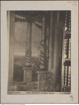 Vorderseite von Biblioteca Apostolica Vaticana [https://www.deutsche-digitale-bibliothek.de/content/lizenzen/rv-ez/] Weite Landschaften hinter illusionistischer Kolonnade mit bekrönender BalustradeHügellandschaft mit Weg vor weiter Ebene - Ausschnitt der Landschaftsdarstellung, davor Handlauf, bh022022_recto. Foto: Moscioni, Romualdo.