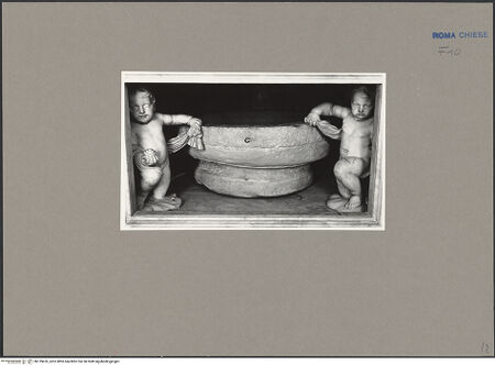 Vorderseite von ICCD [https://www.deutsche-digitale-bibliothek.de/content/lizenzen/rv-ez/] Taufstein der heiligen Franziska Romana flankiert von barocken Putten - Gesamtansicht mit Teil der Rahmung, bh139476_recto. Foto.