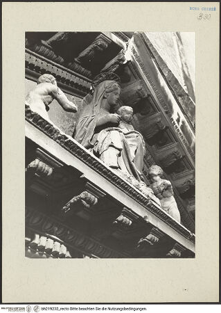 Vorderseite von ICCD [https://www.deutsche-digitale-bibliothek.de/content/lizenzen/rv-ez/] Mittelportal mit Dreiecksgiebel über kompositen DreiviertelsäulenMadonna, flankiert von zwei knienden Gestalten - Ansicht von links unten, bh219232_recto. Foto.