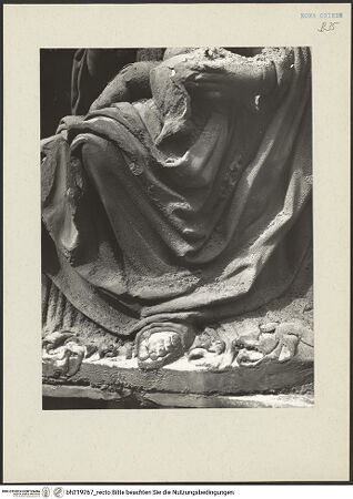 Vorderseite von ICCD [https://www.deutsche-digitale-bibliothek.de/content/lizenzen/rv-ez/] Mittelportal mit Dreiecksgiebel über kompositen DreiviertelsäulenMadonna, flankiert von zwei knienden Gestalten - Maria, Unterkörper, Detail: Gewand, von rechts, bh219267_recto. Foto.