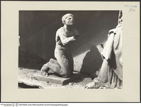 Vorderseite von ICCD [https://www.deutsche-digitale-bibliothek.de/content/lizenzen/rv-ez/] Mittelportal mit Dreiecksgiebel über kompositen DreiviertelsäulenMadonna, flankiert von zwei knienden Gestalten - Linke kniende Figur, von rechts, bh219296_recto. Foto.