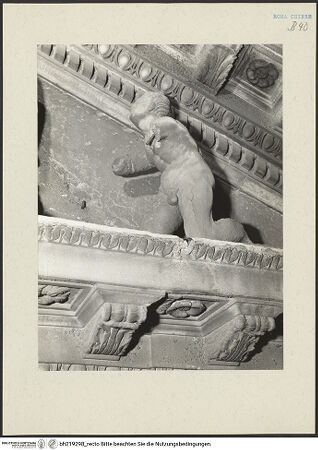 Vorderseite von ICCD [https://www.deutsche-digitale-bibliothek.de/content/lizenzen/rv-ez/] Mittelportal mit Dreiecksgiebel über kompositen DreiviertelsäulenMadonna, flankiert von zwei knienden Gestalten - Rechte kniende Figur, von unten, bh219298_recto. Foto.