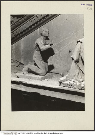 Vorderseite von ICCD [https://www.deutsche-digitale-bibliothek.de/content/lizenzen/rv-ez/] Mittelportal mit Dreiecksgiebel über kompositen DreiviertelsäulenMadonna, flankiert von zwei knienden Gestalten - Linke kniende Figur, von rechts, bh219304_recto. Foto.