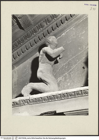 Vorderseite von ICCD [https://www.deutsche-digitale-bibliothek.de/content/lizenzen/rv-ez/] Mittelportal mit Dreiecksgiebel über kompositen DreiviertelsäulenMadonna, flankiert von zwei knienden Gestalten - Linke kniende Figur, rechtes Körperprofil, bh219306_recto. Foto.