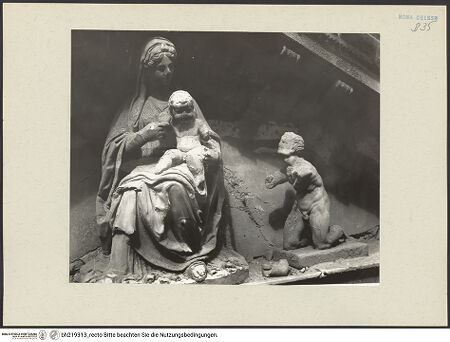 Vorderseite von ICCD [https://www.deutsche-digitale-bibliothek.de/content/lizenzen/rv-ez/] Mittelportal mit Dreiecksgiebel über kompositen DreiviertelsäulenMadonna, flankiert von zwei knienden Gestalten - Detail: Madonna und rechte kniende Figur, bh219313_recto. Foto.