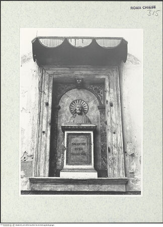 Vorderseite von Sopr. BAS ROMA [https://www.deutsche-digitale-bibliothek.de/content/lizenzen/rv-ez/] Sant'Angelo in PescheriaHauptfassade (Portico dell'Ottavia) / Südfassade - Detail: Ädikula mit Büste des Erlösers; Mitte 15. Jahrhundert, bh444743_recto. Foto.