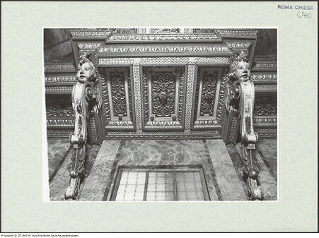 Vorderseite von Sopr. BAS ROMA [https://www.deutsche-digitale-bibliothek.de/content/lizenzen/rv-ez/] Presbyterium, Fensterbedachung, gestützt von Volutenkonsolen in Form von Cherubim, Holz, vergoldet, 1601/1700, bh467547_recto. Foto.