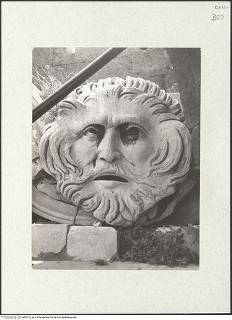 Vorderseite von Sopr. BAS NA [https://www.deutsche-digitale-bibliothek.de/content/lizenzen/rv-ez/] Triumphbogen Alfonsos VGiebelfeld mit zwei Figuren, sogenannte Flussgötter, und Blattgirlande mit zwei Masken - Rahmung, Detail: rechte Maske, bh480725_recto. Foto.