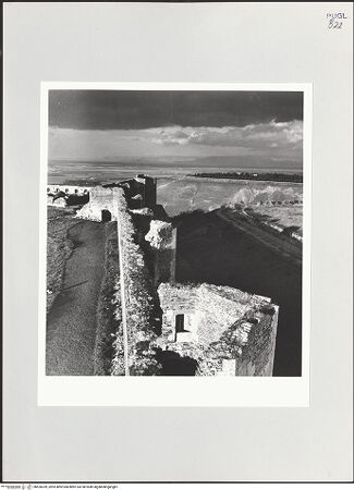 Vorderseite von Bibliotheca Hertziana [https://www.deutsche-digitale-bibliothek.de/content/lizenzen/rv-fz/] Fortezza AngioinaInnenhof - Ostmauer von Süden; im Hintergrund: Ruine des Palastes Friedricks II. (links) und Innenseite des Hauptportals (rechts), bh526359_recto. Foto: Schwarz, Heinrich Mathias.