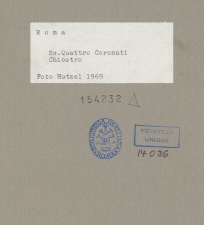 Rückseite von Hutzel, Max [https://www.deutsche-digitale-bibliothek.de/content/lizenzen/rv-fz/] Santi Quattro CoronatiInneresLapidarium - Antike Kapitelle beidseitig der Tür zum Klausurbereich, bh154232_recto. Foto: Hutzel, Max.