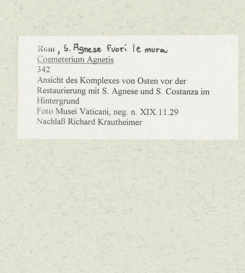 Rückseite von Musei Vaticani [https://www.deutsche-digitale-bibliothek.de/content/lizenzen/rv-ez/] Coemeterium Agnetis - Ansicht des Komplexes von Osten vor der Restaurierung mit S. Agnese und S. Costanza im Hintergrund, bh484428_recto. Foto.