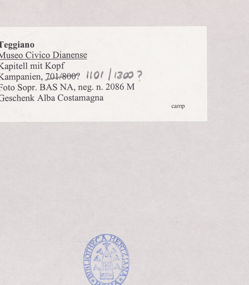 Rückseite von Sopr. BAS NA [https://www.deutsche-digitale-bibliothek.de/content/lizenzen/rv-ez/] Kapitell mit Kopf und Lilie - Frontalansicht, bh508103_recto. Foto.